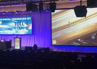 an event stage, likely a conference or forum, sponsored by a company named TOLLPLUS.